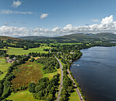 Aerial view of beautiful Loch Lomond surrounded by lush greenery and hills in Trossachs National Park, Alexandria, United Kingdom.
