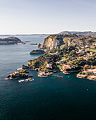 Aerial view of beautiful cliffs and vibrant coastline along the azure sea, Naples, Italy.