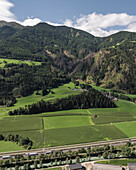 Luftaufnahme von üppig grünen Tälern und majestätischen Bergen, umgeben von ruhigen Wäldern und Feldern, Freienfeld, Italien