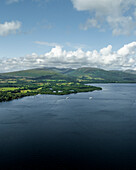 Aerial view of Loch Lomond surrounded by majestic mountains and serene clouds, Alexandria, United Kingdom.