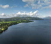 Aerial view of serene Loch Lomond surrounded by majestic mountains and lush greenery, Trossachs National Park, Scotland, United Kingdom.