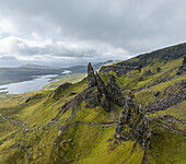 Aerial view of the majestic Old Man of Storr rock formation amidst rugged mountains and serene landscapes, Portree, United Kingdom.