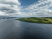 Aerial view of serene Loch Lomond surrounded by lush greenery and majestic mountains, Alexandria, United Kingdom.