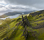 Aerial view of the iconic Old Man of Storr rock formation amidst rugged mountains and lush greenery, Scottish Highlands, Isle of Skye, United Kingdom.