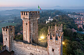 Aerial view of scaligero castle and italian flag in a beautiful sunset over the medieval town of Valeggio sul Mincio, Verona, Italy.