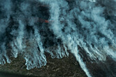 Aerial view of mystical smoke and dramatic cloud formations over a serene landscape, Grindavik, Iceland.