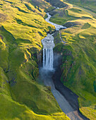 Aerial drone view of Skógafoss waterfall during sunrise in summer time, Southern Iceland.