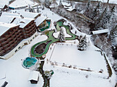 Aerial view of outdoor swimming area covered in snow in winter, Valais, Switzerland.