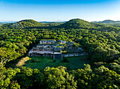 Aerial view of ancient ruins surrounded by lush forest and jungle, Oxkutzcab, Yucatan, Mexico.