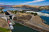 Luftaufnahme des schönen The Dalles Dam mit einem Lastkahn auf dem Fluss, The Dalles, Oregon, Vereinigte Staaten.