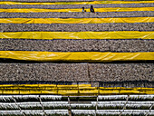 Cox Bazar, Bangladesh - 29 November 2022: Aerial view of dried fish processing with yellow tarps and people at work, Cox Bazar, Bangladesh.