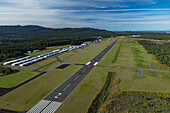 Aerial view of Bremerton National Airport with runway and hangars surrounded by serene greenery and forest, Bremerton, Washington, United States.