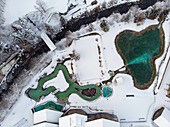 Aerial view of outdoor swimming area covered in snow in winter, Valais, Switzerland.