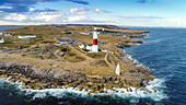 Luftaufnahme des Leuchtturms Portland Bill mit Wellen, die an Felsen krachen, Uk.