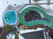 Aerial view of outdoor swimming area covered in snow in winter, Valais, Switzerland.