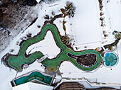 Aerial view of outdoor swimming area covered in snow in winter, Valais, Switzerland.