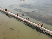 Aerial view of a coastal village with people collecting water in a drought-affected area, Khulna, Bangladesh.