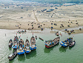Aerial view of fishing boats and bustling fishermen at fishery ghat by the Bay of Bengal, Cox Bazar, Bangladesh.