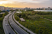 Aerial view of tirana artificial lake park with urban skyline and greenery at sunset, tirana, albania.