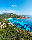 Aerial drone view of Plage de Roccapina, bay filled with sailing boats, Mediterranean beach during summer, island of Corsica, France.