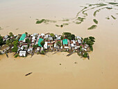 Aerial view of flooded village with waterlogged houses and boats, Balijuri, Tahirpur, Sylhet, Bangladesh.
