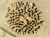 Aerial view of a rural landscape with bags and sacks arranged in a circular pattern in a field, Kastail, Bangladesh.