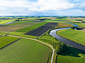 Aerial view of the tranquil countryside with a curving river Reitdiep surrounded by lush cropland and a road, Ezinge, Netherlands.