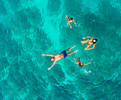 Luftaufnahme einer 4-köpfigen Familie beim Schwimmen im türkisfarbenen Meer der Adria, Sutivan, Kroatien.