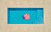 Luftaufnahme eines Mädchens, das auf einem aufblasbaren Flamingo im Pool liegt, Sumarti, Kroatien.