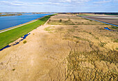 Aerial view of open nature area with reedland and dike along lake Ketelmeer, Roggebotveld, Dronten, Flevoland, Netherlands.