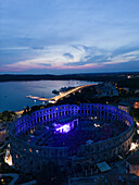 Aerial view of the Pula Amphitheater arena during a concert at sunset, a Roman Amphitheater with underground museum in Pula downtown, Istria, Croatia.