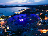 Aerial view of the Pula Amphitheater arena during a concert at sunset, a Roman Amphitheater with underground museum in Pula downtown, Istria, Croatia.