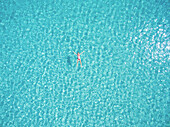 Beautiful woman swimming in transparent sea