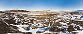 Panoramablick aus der Vogelperspektive auf erstaunliche Schneespuren im Geitlandsrhaun-Lavafeld vor dem Langjokul-Gletscher und den Bergen Strutur und Hafrafell, Island