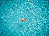 Beautiful woman swimming in transparent sea