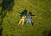 Aerial view of family laying down on grass at public playground, Zagreb.