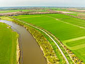 Aerial view of river Linge and bicycle path with apple trees, Marienwaerdt, Betuwe, Gelderland, Netherlands.