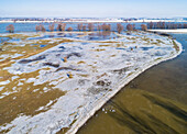 Luftaufnahme von Eis- und Schneeresten auf teilweise überfluteten Überschwemmungsgebieten entlang des Flusses Waal, Beuningse Uiterwaarden, Gelderland, Niederlande.