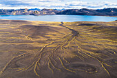 Aerial view of green lines on a mountainside with lake and mountains in Veidivotn in the highlands of Iceland