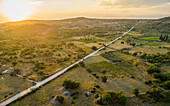 Panoramablick auf die lange Straße in Nerezisca dalmatinischen Dorf mit Hügeln bei Sonnenuntergang, Brac Island, Kroatien.