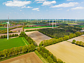 Aerial view of wind turbines, farmland and small forest, Muensterland, Nordrhein-Westfalen, Germany.