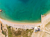 Luftaufnahme von oben der Sonnenschirme am Strand Vela luka, Baska, Insel Krk, Kroatien.