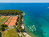 Luftaufnahme von Tennisplätzen und einem Wasserspielplatz für Kinder am Strand von Valkane, Pula, Istrien, Kroatien.