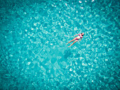 Beautiful woman swimming in transparent sea