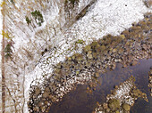 Aerial view of edge of a lake in nature area Witte Veen covered with snow, Twente, Overijssel, Netherlands.