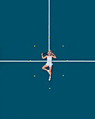 Aerial drone view of a female tennis player laying on a blue tennis court in Melbourne, Victoria, Australia.