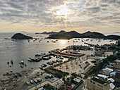 Der Hafen von Labuan Bajo mit einem im Meer segelnden Boot und dem Stadtbild, Touristenziel in Indonesien.