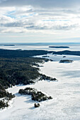 Aerial view of frozen Lake Ladoga surrounded by serene forests and snowy islands, Karelia Republic, Russia.