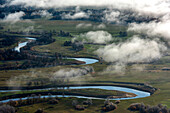 Aerial view of serene meandering river surrounded by lush greenery and picturesque countryside, Great Gurez Pudga, Udmurtia, Russia.