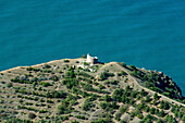 Aerial view of a picturesque coastline with a historic fortress on a hill surrounded by blue water and greenery, Chaban Calais, Crimea, Russia.